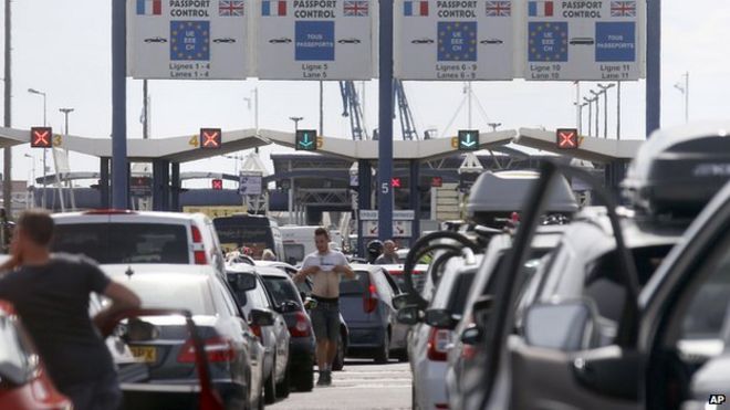 Пассажиры паромов, направляющиеся в Англию, выстраиваются в очередь на автомобильном паромном терминале в Кале