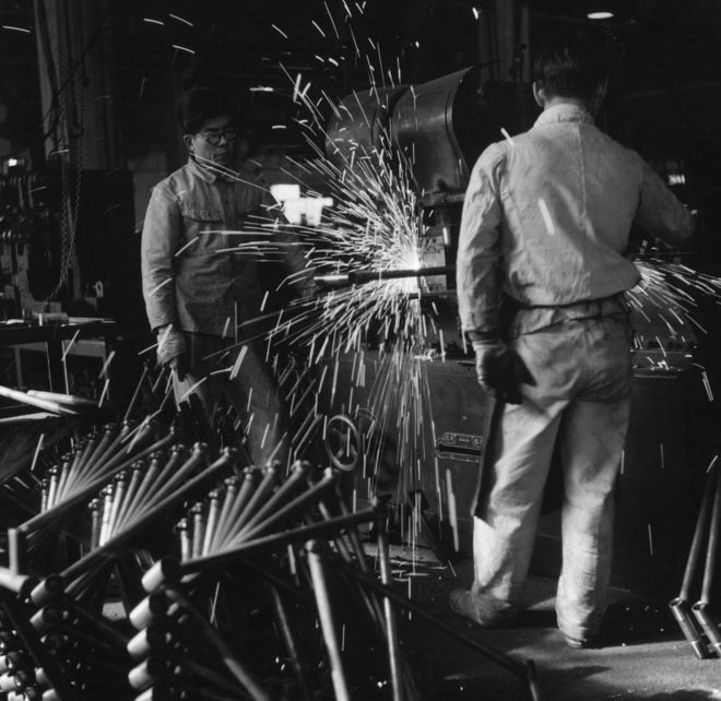 Искры вылетают из машины, производящей велосипедные рамы на японской фабрике, около 1953 года