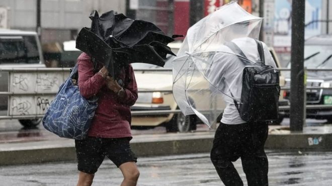 Two pedestrians (not the homeless people in question) brave the storm on Saturday in Tokyo