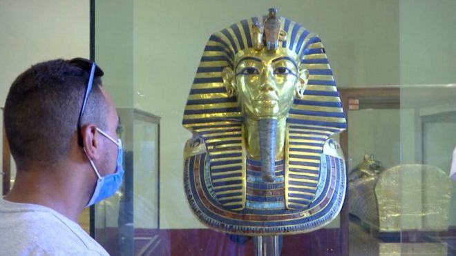 Man wearing a face mask looks at the King Tutankhamun exhibit in Cairo