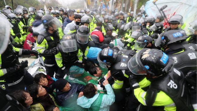 Полицейские Южной Кореи пытаются разогнать жителей, участвующих в акции протеста против THAAD (Терминальная защита высокогорных районов) в Сонджу, Южная Корея, 23 апреля 2018 г.