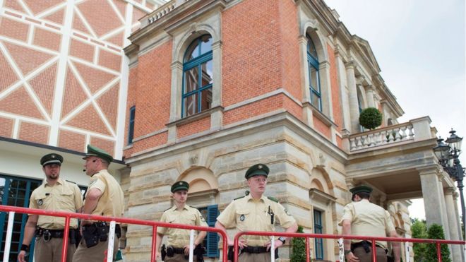Члены немецкой полиции видят за барьерами, которые были установлены перед фестивальным залом перед открытием Байройтского фестиваля