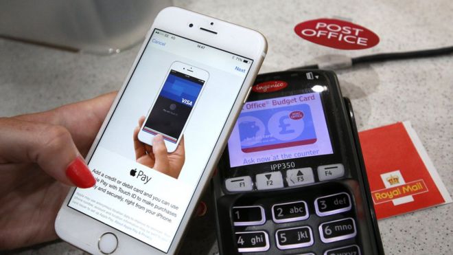 На этом фото иллюстрации iPhone используется для покупки Apple Pay в почтовом отделении 14 июля 2015 года в Лондоне, Англия.