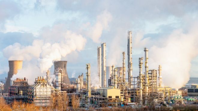 Пар и дым поднимаются из ректификационных колонн и градирен влево на нефтеперерабатывающем и нефтехимическом заводе в Гранжмуте в Центральной Шотландии.