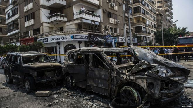 Выгоревшие автомобили видны на месте взрыва бомбы, нацеленного на конвой государственного обвинителя Египта Хишама Бараката, который умер через несколько часов после мощного взрыва, нанесенного его конвою, в столице Каире 29 июня 2015 года.