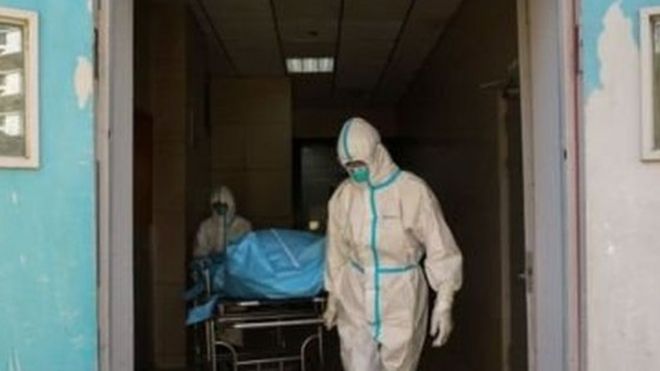 Medical staff carrying the body of a patient killed by the coronavirus in Wuhan