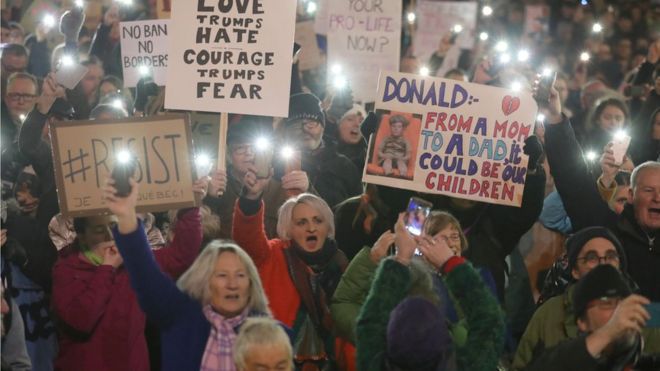 Демонстранты держат плакаты во время акции протеста в Глазго против спорного запрета на поездках президента США Дональда Трампа по вопросам беженцев и людям из семи преимущественно мусульманских стран