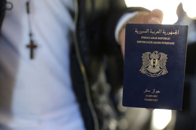 Мужчина держит свой сирийский паспорт
