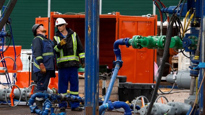 Экипаж скважины стоит рядом с колонной труб, когда разработчик сланцевого газа Cuadrilla Resources готовится начать добычу газа на своем участке Preston New Road возле Блэкпула,