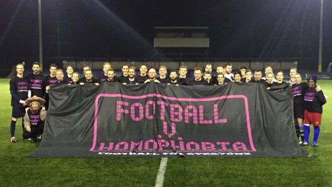 Футболисты держат плакат «Футбол против гомофобии»