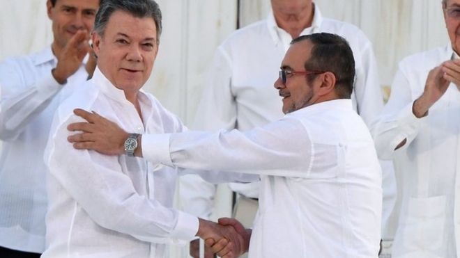 Президент Сантос и Тимоченко пожимают друг другу руки после подписания мирного соглашения