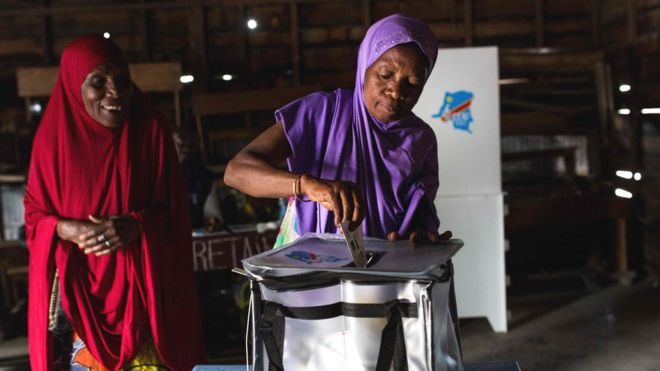 Voter putting a ballot paper in a box