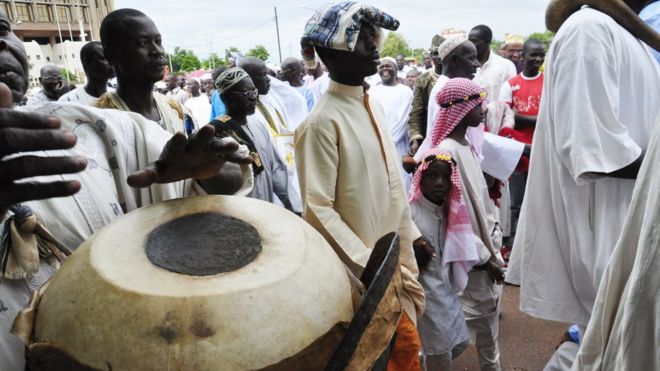 Мужчина играет на барабане во время празднования Ид в Уагадугу, Буркина-Фасо
