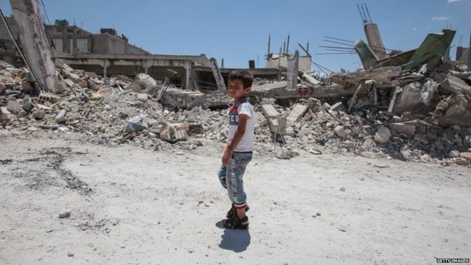 Мальчик проходит мимо разрушенных зданий в Кобане 20 июня