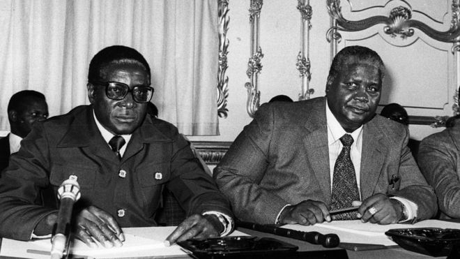 Robert Mugabe (kushotot) na Joshua Nkomo katika Lancaster House, Jijiji London.