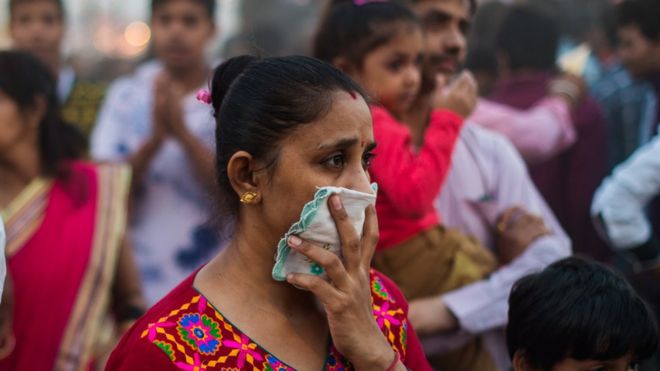 Woman shields her nose from smoke