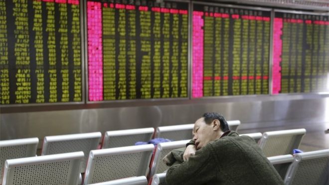 Инвестор дремлет перед электронной доской с информацией об акциях в брокерском доме в Пекине