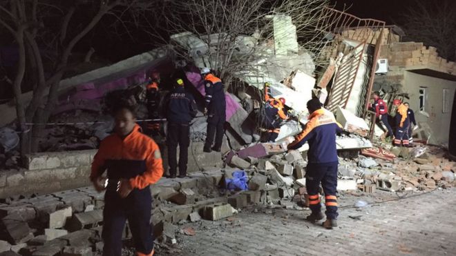 Rescuers at the destroyed police HQ in Cinar
