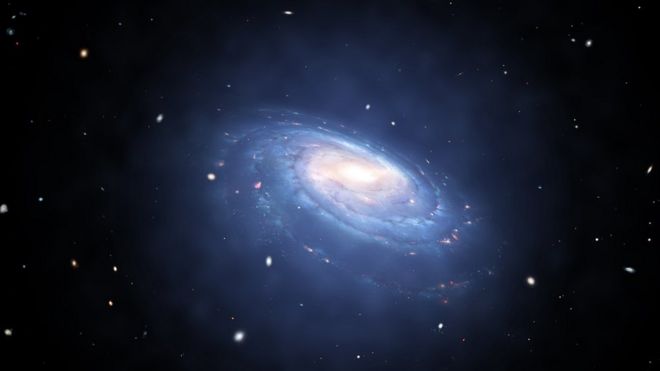 Художественный образ спиральной галактики с голубыми рукавами из пыли и звезд.Его окружает слабое голубое свечение.