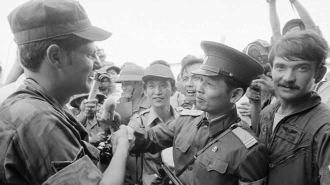 N. Vietnamese Lt. Col. Bui Tin (r), official spokesman for the N. Vietnamese delegation to the JMC, shakes hands with unidentified American Airforce SGT