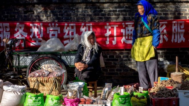 중국 윈난성 리장에 위치한 시장에서 물건을 팔고있는 여성