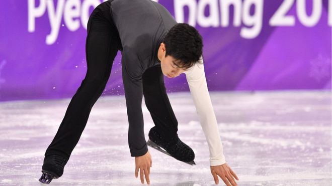 USA's Nathan Chen touches the ice as he skates during the men's short program