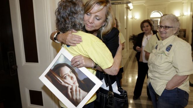 Дебби Циглер, держащая фотографию своей дочери Бриттани Мейнард, обнимает сторонницу после того, как мера пройдена