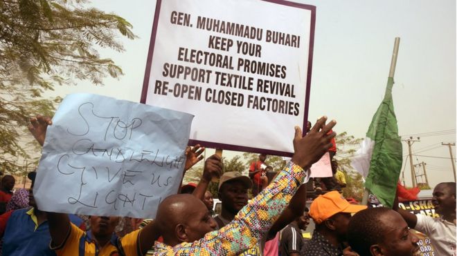Люди, державшие плакаты на февральской демонстрации, просили президента Бухари выполнить предвыборные обещания о возрождении текстиля, открыв закрытые фабрики.