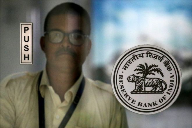 Сотрудник идет за логотипом Резервного банка Индии (RBI) в его штаб-квартире в Мумбаи, Индия, 5 октября 2018 года