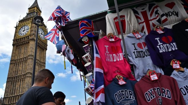 Туристы смотрят на лондонские тематические товары с Биг Беном на заднем плане