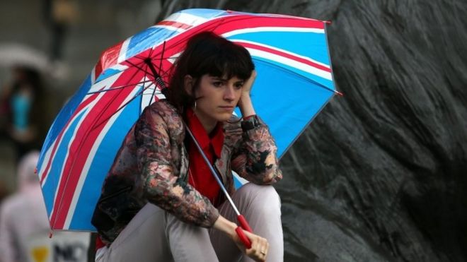 A demonstrator shelters under a Union Jack umbrella during an anti-Brexit protest in London, 28 June 2016