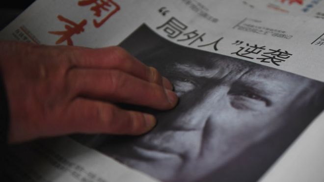 Мужчина покупает китайскую газету с заголовком «Аутсайдер наносит ответный удар