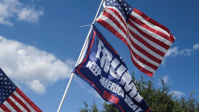 A Trump campaign flag and US flag