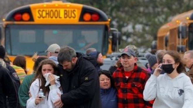 Родители уводят своих детей от здания школы в штате Мичиган