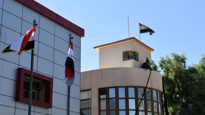 Национальный флаг Ирака качается на ветру над зданием мухафазы Киркук в многонациональном городе на севере Ирака (17 октября 2017 года)
