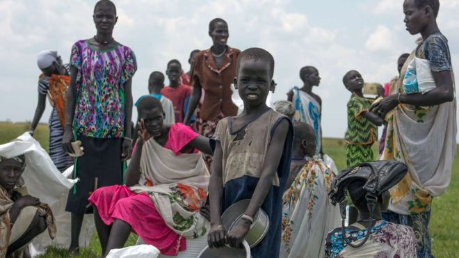 Внутренне перемещенные женщины и дети, ожидающие своего рациона питания после гуманитарного взлета Мировой продовольственной программы