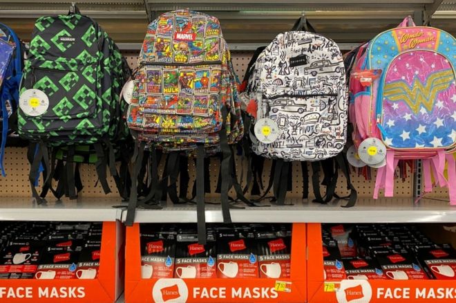 Маски для лица выставлены на продажу с рюкзаками и обратно к школьным принадлежностям в магазине Walmart во время вспышки коронавирусной болезни в Калифорнии