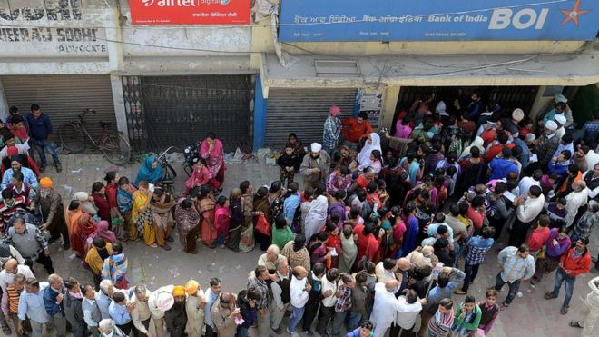 Индийцы стоят в очереди возле банка, ожидая внесения депозита и обмена 500 и 1000 рупий в Амритсаре