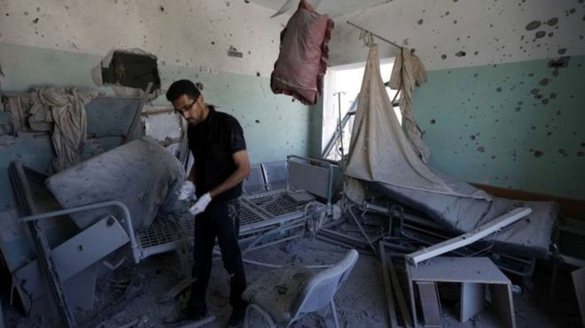 Палестинский служащий осматривает повреждения в больнице Аль-Акса в Дейр-эль-Балахе