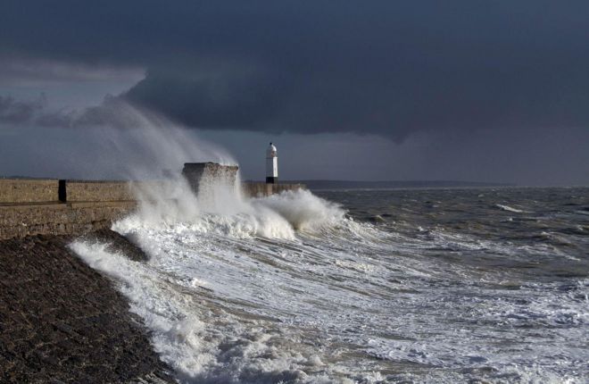 Волны разбиваются о пляж в Porthcawl Bridgend, южное побережье Уэльса