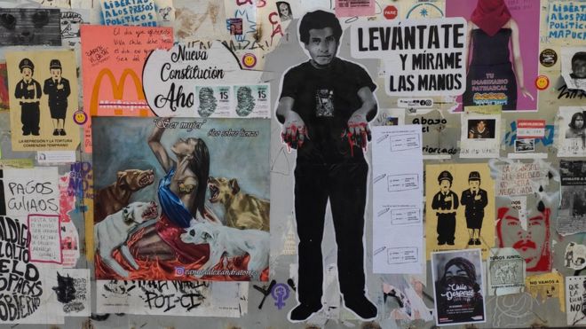 Фотография стены в Сантьяго, покрытой граффити и уличным искусством