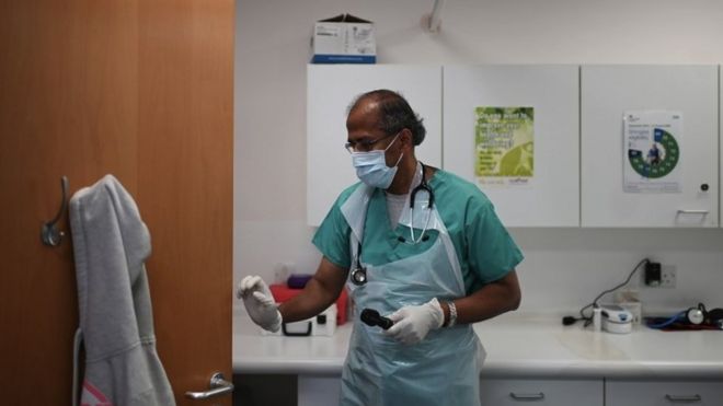 Врач носит СИЗ в медицинской клинике в Гримсби в июне 2020 года