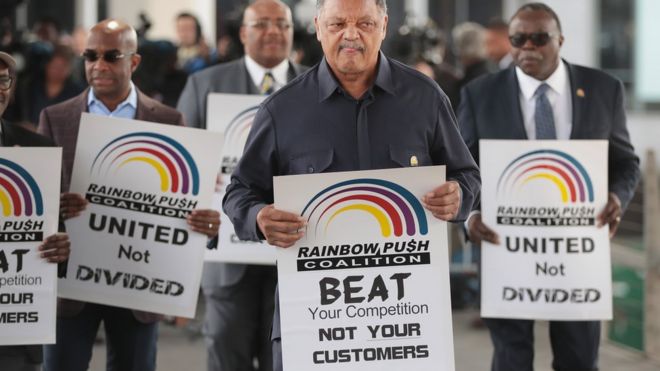 Лидер за гражданские права Преподобный Джесси Джексон возглавляет небольшую группу из коалиции Rainbow PUSH в знак протеста возле терминала United Airlines в международном аэропорту О'Хара, 12 апреля 2017 года