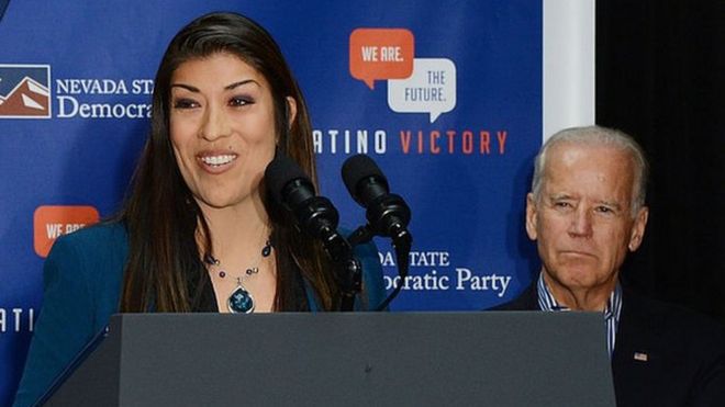 Lucy Flores speaking at a 2014 Nevada campaign event with Joe Biden behind her