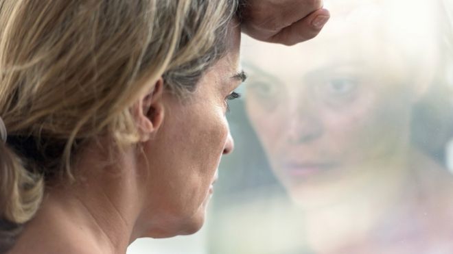 Mujer mirando por la ventana