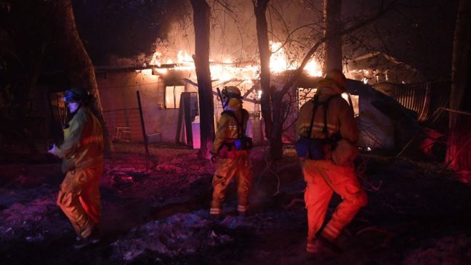 Пожарные расследуют горящий дом, так как лесной пожар Томаса продолжает гореть в Карпинтерии, Калифорния, 10 декабря 2017 года