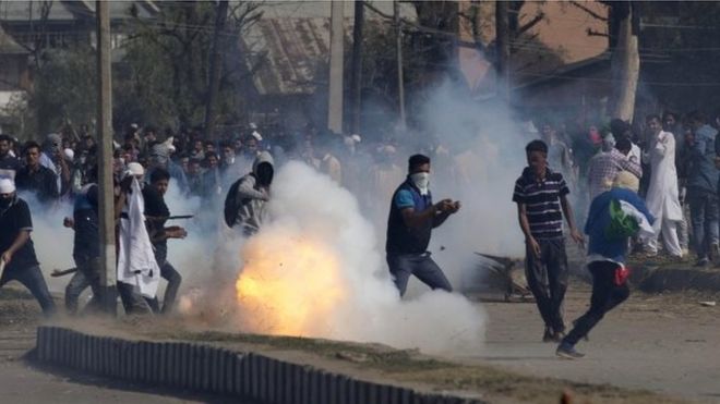 Раковина слезоточивого газа взрывается перед кашмирцами, протестующими возле Eidgah, молитвенной площадки, в Сринагаре, контролируемом Индией Кашмире,