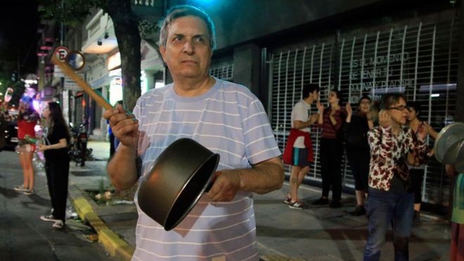 Hombre protestando con una cacerola en Buenos Aires
