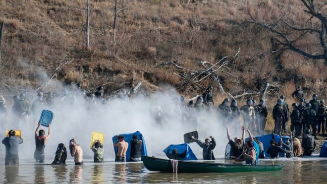 Полиция использует перцовый баллончик против людей, стоящих в воде реки во время акции протеста против строительства трубопровода в индейской резервации Стоячий камень возле пушечного ядра, Северная Дакота, 2 ноября 2016 г.