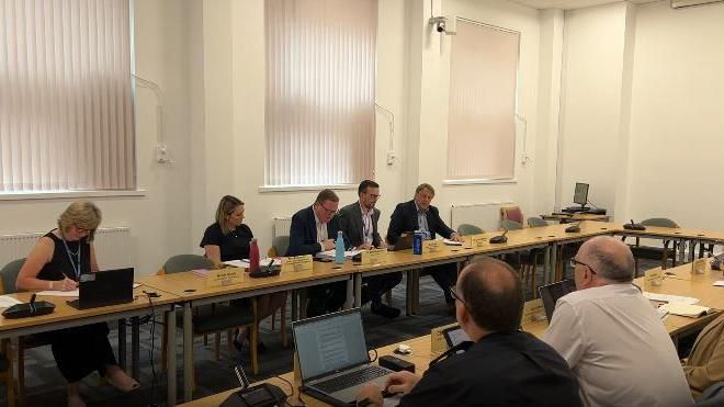 Mark Hawthorne reading his resignation speech at a table at a council meeting